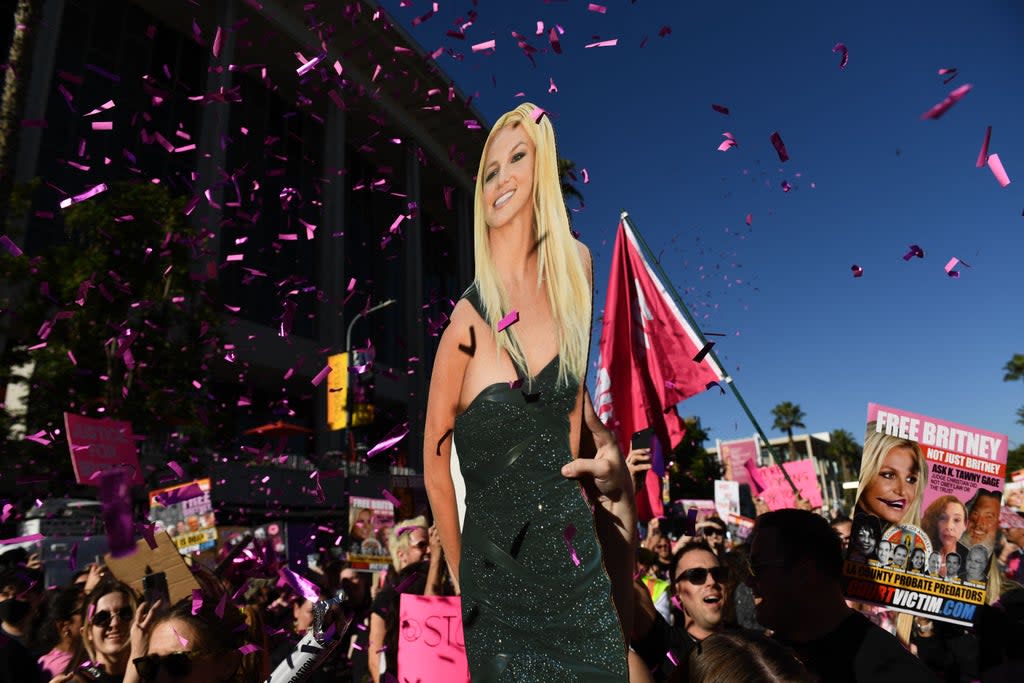 Supporters of the #FreeBritney movement celebrate following a court decision ending her conservatorship outside the Stanley Mosk courthouse in Los Angeles, California on 12 November  (AFP via Getty Images)