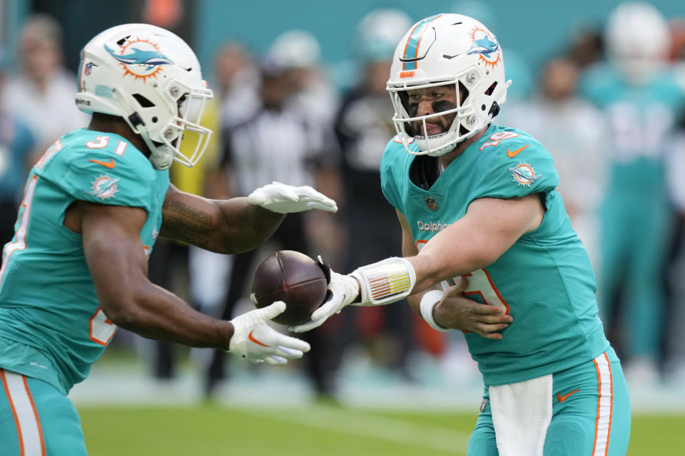 Miami Dolphins quarterback Skylar Thompson (19) hands the ball to running back Raheem Mostert (31) during the first half of an NFL football game against the New York Jets, Sunday, Jan. 8, 2023, in Miami Gardens, Fla. (AP Photo/Lynne Sladky)