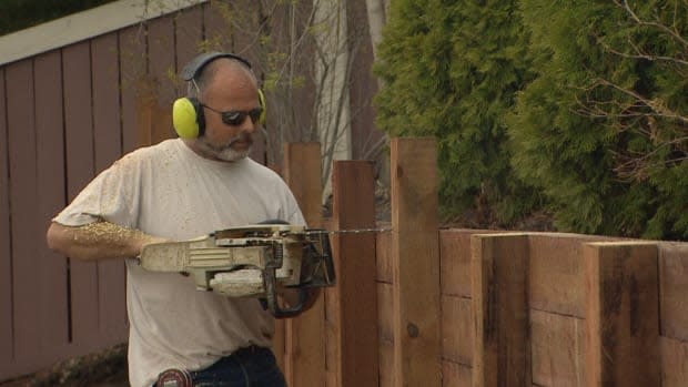 Scott MacTavish, co-owner of Wild Rose Fencing and Decks, puts the finishing touches on a retaining wall in the community of Brookview. 