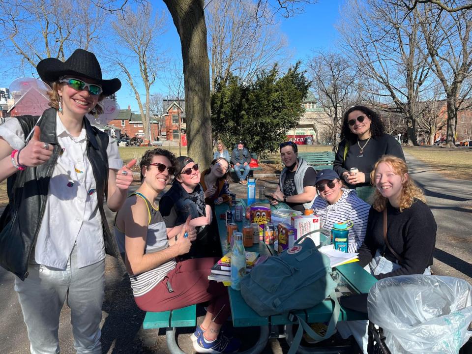 Morgan Mercury, at the far left, gathers with walking tour participants around a picnic table in Dundonald Park on April 7, 2024.