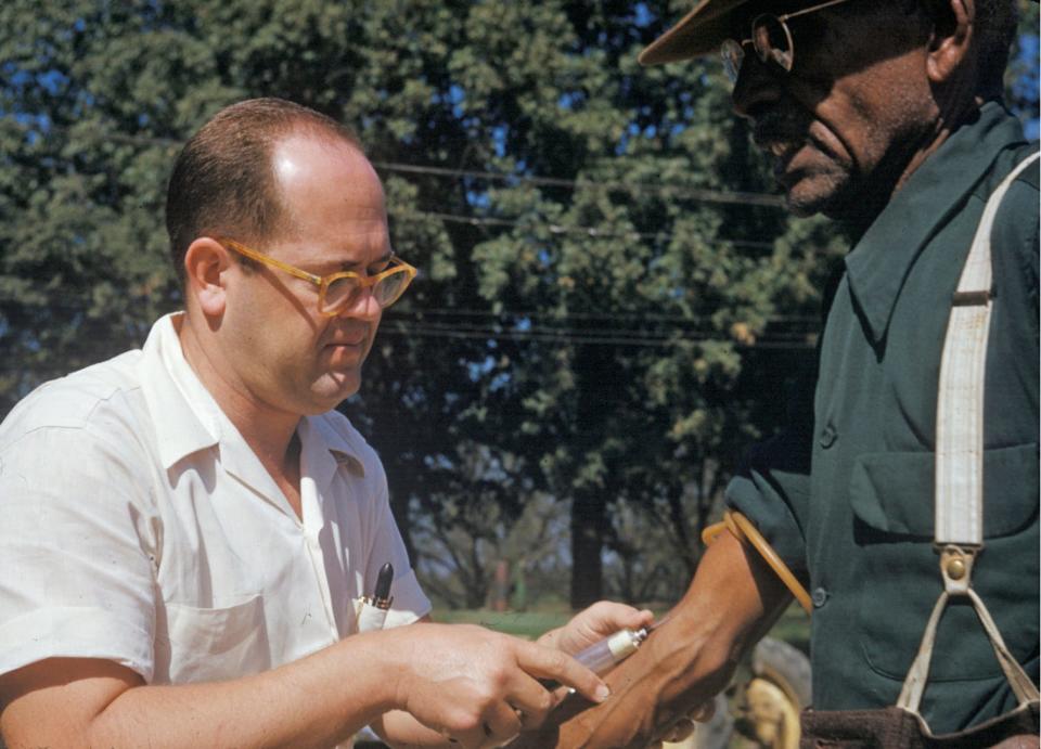 In this 1950's photo released by the National Archives, a black man included in a syphilis study has blood drawn by a doctor in Tuskegee, Ala. For 40 years starting in 1932, medical workers in the segregated South withheld treatment for unsuspecting men infected with a sexually transmitted disease simply so doctors could track the ravages of the horrid illness and dissect their bodies afterward. Finally exposed in 1972, the study ended and the men sued, resulting in a $9 million settlement. 