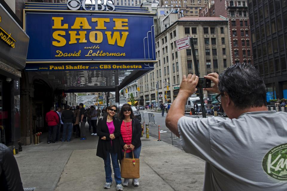 A fan stops to take a photograph of the outside of Ed Sullivan Theater in Manhattan as David Letterman prepares for the taping of tonight's final edition of "The Late Show" in New York