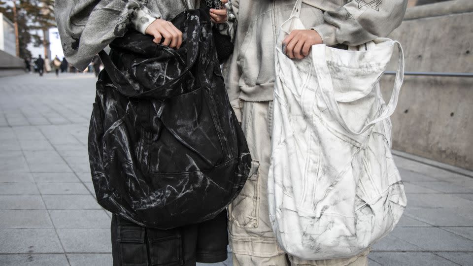 Jeong Yoon-gyeong, left, and Lee Yosep, right, wear gray bags from South Korean label Nos Couleurs. - Jean Chung/Getty Images