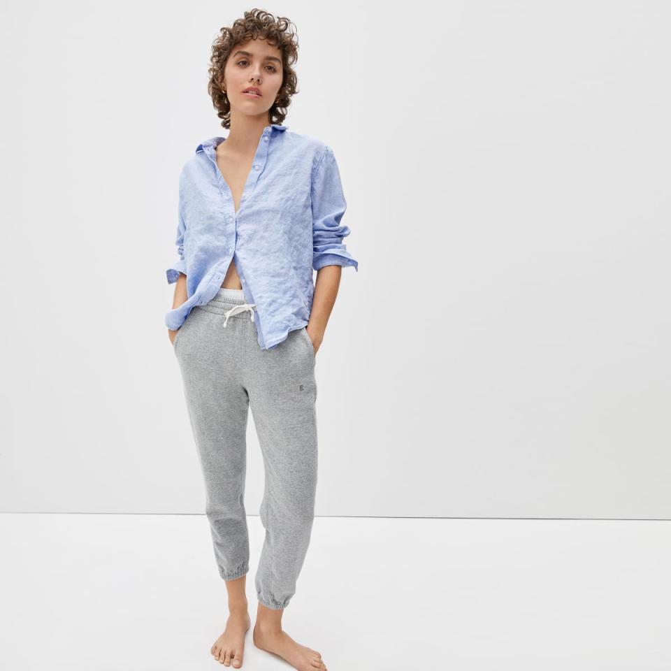 Model wears The Lightweight French Terry Jogger in grey with a blue collared shirt. Image via Everlane.