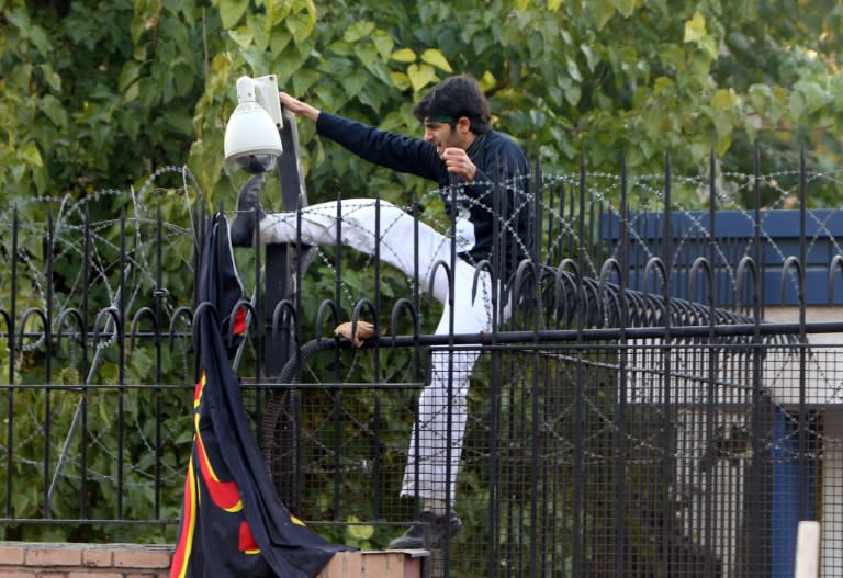 An Iranian protester breaks a security camera inside the British embassy after storming into the compound in Tehran on November 29, 2011