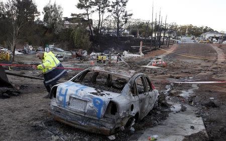 An emergency worker leaves an area devastated by a fire caused by a gas pipeline explosion in a neighborhood in San Bruno, California September 10, 2010. REUTERS/Eric Risberg/Pool