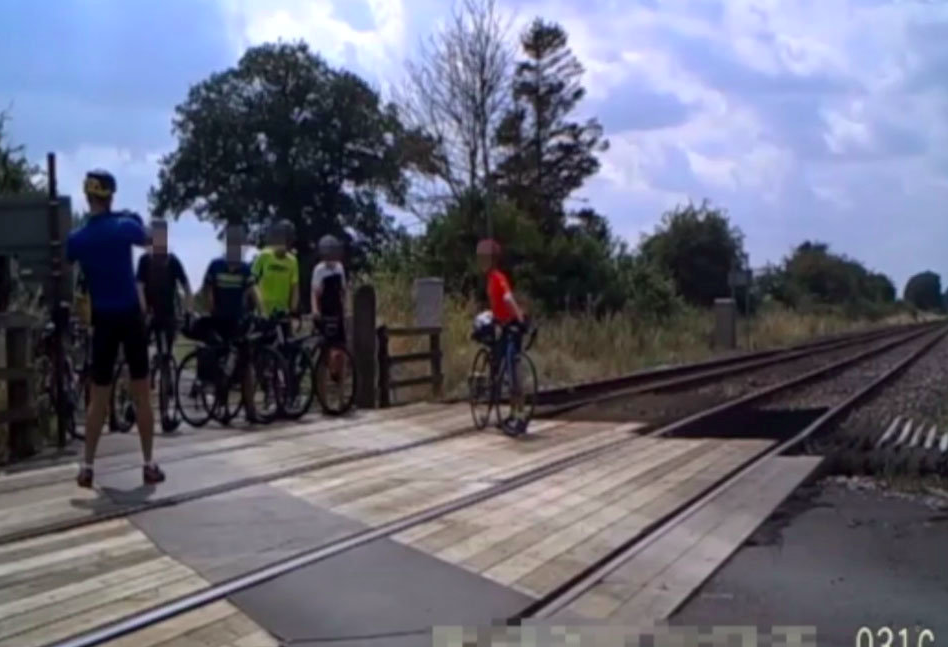 Another moment shows a group of cyclists who dismount their bikes and line up for a group photo on the crossing. (SWNS)