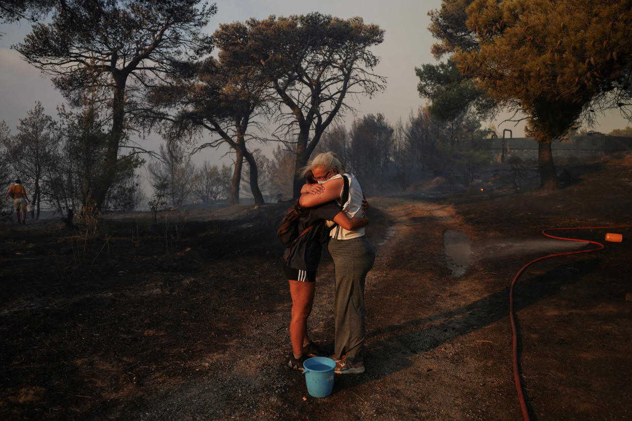 Marina Kalogerakou, 24, hugs her aunt Eleonora Zoakou, 48, as a wildfire burns in Penteli, Greece, on Monday.