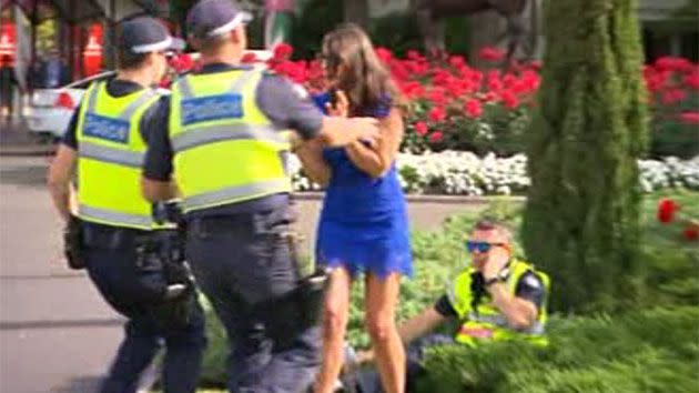 Two on-duty police officers hastily removed the woman in blue from the situation. Photo: 7 News