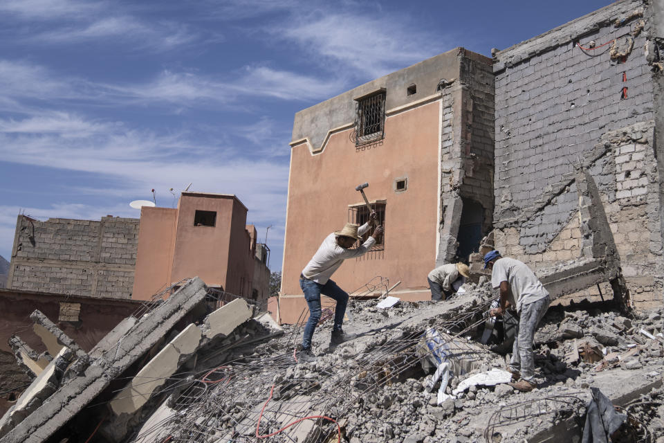 People dig through the rubble caused by September earthquake, in Moulay Ibrahim, outside Marrakech, Morocco, Friday, Oct. 6, 2023. Morocco has pledged to rebuild from a September earthquake in line with its architectural heritage. Villagers and architects agree that earthquake-safe construction is a top priority. That’s created a push for modern building materials. But the government says it wants to rebuild in line with Morocco’s cultural and architectural heritage. (AP Photo/Mosa'ab Elshamy)