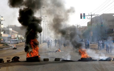 Sudanese protesters burn tyres as they erect barricades on a street and demanding that the country's Transitional Military Council hand over power to civilians in Khartoum