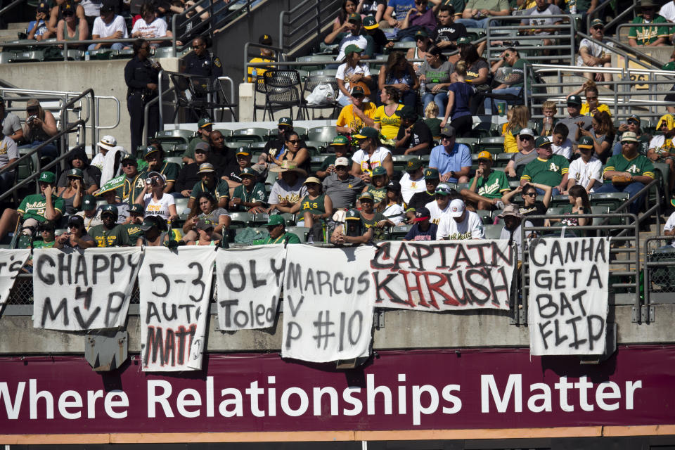 FILE - In this Sept. 22, 2019, file photo, Oakland Athletics fans drape the bleachers with messages for the team during the A's baseball game against the Texas Rangers in Oakland, Calif. Baseball players and owners are currently caught in a bitter dispute over how to start amid the coronavirus pandemic. Both sides occasionally mention fans, talking about doing right by them. But apart from taking sides, how do the fans feel -- would they consider a severely shortened schedule as legit? "I think any rate-based stat record -- batting average, ERA -- would have to be considered an anomaly," Oakland fan Adam Brooks said. (AP Photo/D. Ross Cameron, File)