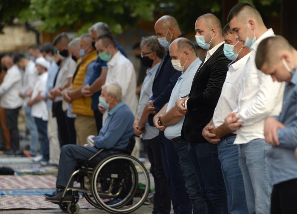 Worshippers wearing masks to help stop the spread of the coronavirus, offer Eid al-Adha prayer in front of the Gazi Husrev-beg mosque in Sarajevo, Bosnia, Friday, July 31, 2020. Muslims worldwide marked the the Eid al-Adha holiday over the past days amid a global pandemic that has impacted nearly every aspect of this year's celebrations. (AP Photo/Kemal Softic)