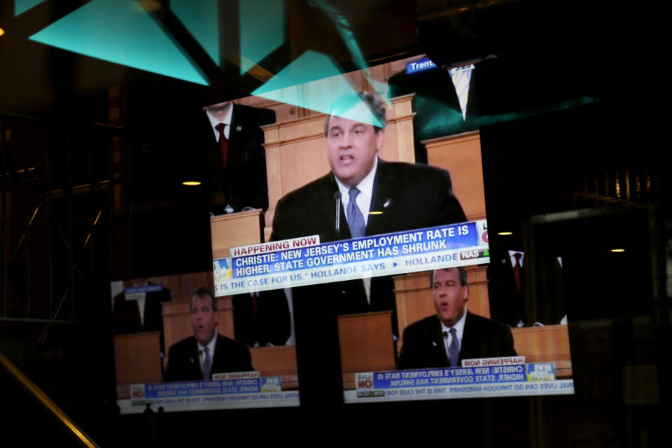 A television tuned to New Jersey Gov. Chris Christie's State of the State address is reflected in the windows at G.W. Grill in Fort Lee, N.J., Tuesday, Jan. 14, 2014. Faced with a widening political scandal that threatens to undermine his second term and a possible 2016 presidential run, Christie apologized again Tuesday, saying his administration "let down the people we are entrusted to serve" but that the issue doesn't define his team or the state. (AP Photo/Seth Wenig)