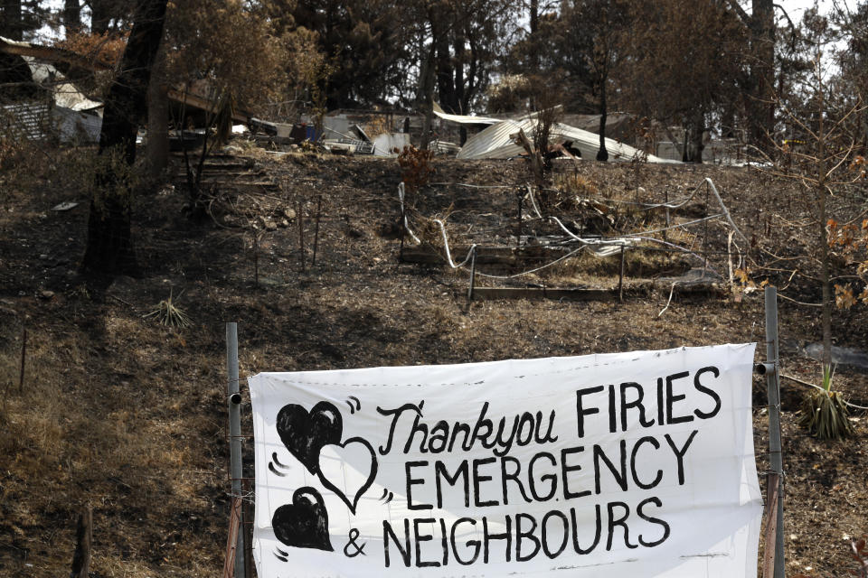 A sign is displayed beside a burned out house near Mogo, Australia, Thursday, Jan. 9, 2020, thanking "firies" a colloquial term for firefighters. House after house in affected areas have hung makeshift banners offering thanks to the people they call "firies." It's a far cry from how many Australians view their leader, Prime Minister Scott Morrison, who has been widely ridiculed for his response to the disaster. (AP Photo/Rick Rycroft)