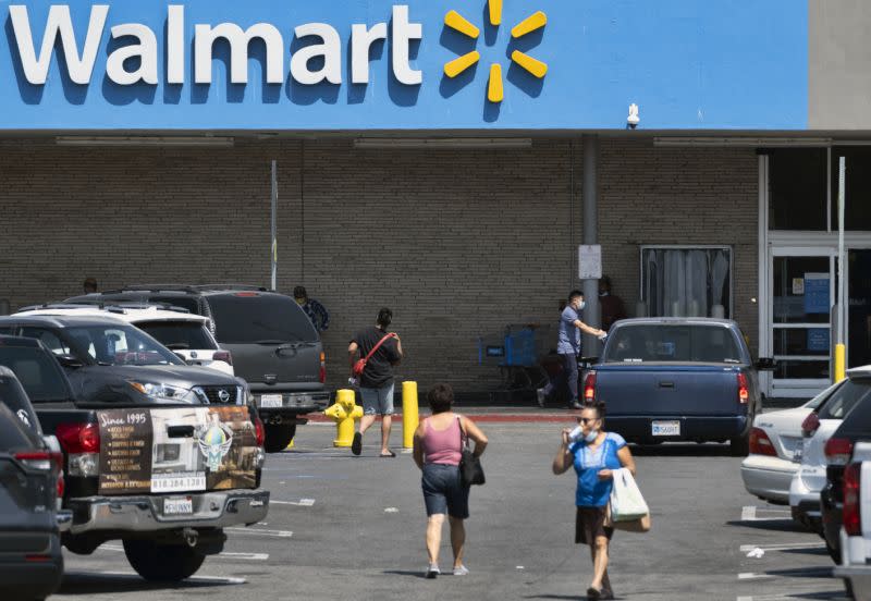 Compradores caminando por un aparcamiento vacío de un Walmart en la sección Panorama City de Los Ángeles el martes 3 de agosto de 2020. Un problema técnico ha provocado un retraso en el recuento de los resultados de los test de coronavirus en California, lo que pone en duda la precisión de los datos recientes que muestran una mejoría en la tasa de infección y obstaculizan los esfuerzos por rastrear la propagación del virus. (Foto AP/Richard Vogel)