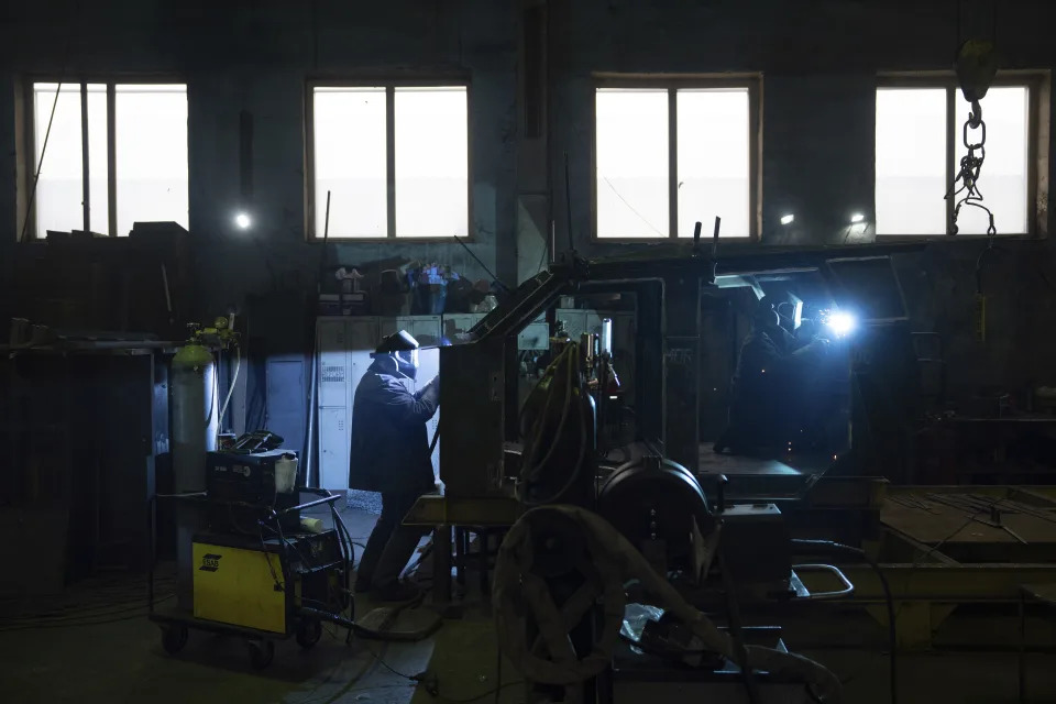 Workers weld reinforced steel for armored vehicles at a factory in Ukraine, on Friday, December 22, 2023. (AP Photo/Evgeniy Maloletka)