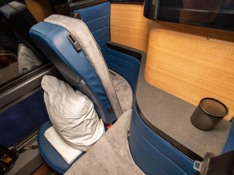 A seat pulled forward as it holds a pillow. There's a small table with a cup holder next to the seat.