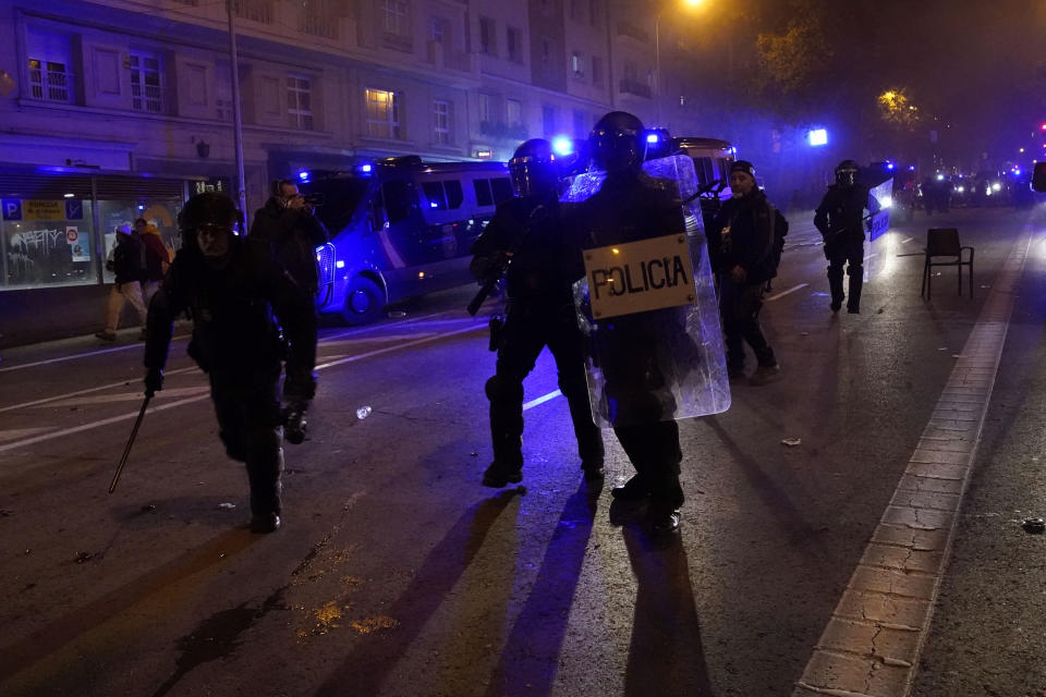 Anti riot police officers try to disperse protesters during a demonstration against the amnesty at the headquarters of Socialist party in Madrid, Spain, Thursday, Nov. 9, 2023. Protests backed by Vox party turned on Thursday night as Spain's Socialists to grant amnesty to Catalan separatists in exchange for support of new government. (AP Photo/Andrea Comas)