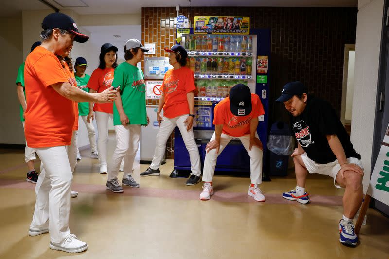 Miembros de Ara Style Senior, el único club de breakdance de Japón formado por ciudadanos de edad avanzada, se estiran mientras esperan a que comience su actuación en un festival local en Tokio, Japón