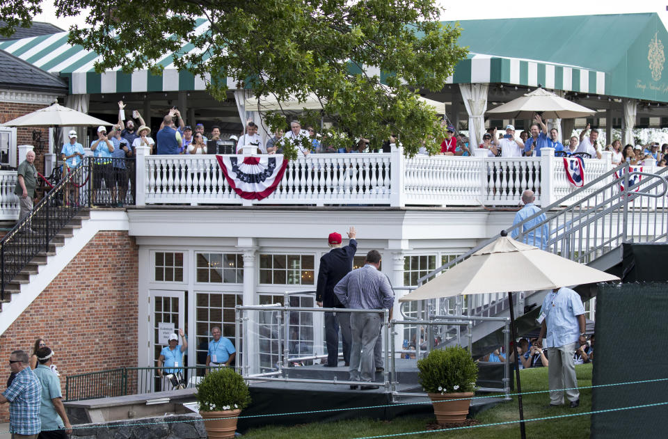 FILE - In this July 15, 2017 file photo, President Donald Trump turns to wave to people gathered at the clubhouse as his walks to his presidential viewing stand during the U.S. Women's Open Golf tournament at Trump National Golf Club in Bedminster, N.J. Trump’s true financial picture has gotten renewed scrutiny in the wake of a New York Times report in September 2020 that he declared hundreds of millions in losses in recent years, allowing him to pay just $750 in taxes the year he won the presidency, and nothing for 10 of 15 years before that. (AP Photo/Carolyn Kaster, File)