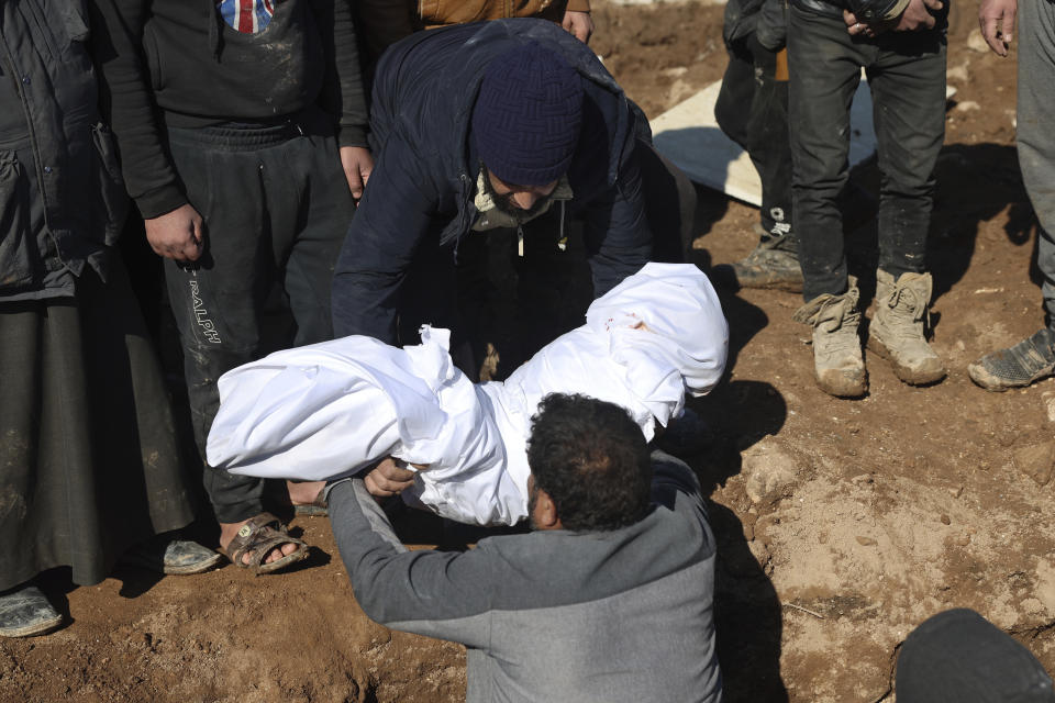 Mourners bury family members who died in a devastating earthquake that rocked Syria and Turkey at a cemetery in the town of Jinderis, Aleppo province, Syria, Tuesday, Feb. 7, 2023. A newborn girl was found buried under debris with her umbilical cord still connected to her mother, Afraa Abu Hadiya, who was found dead, according to relatives and a doctor. The baby was the only member of her family to survive from the building collapse Monday in Jinderis, next to the Turkish border, Ramadan Sleiman, a relative, told The Associated Press. (AP Photo/Ghaith Alsayed)