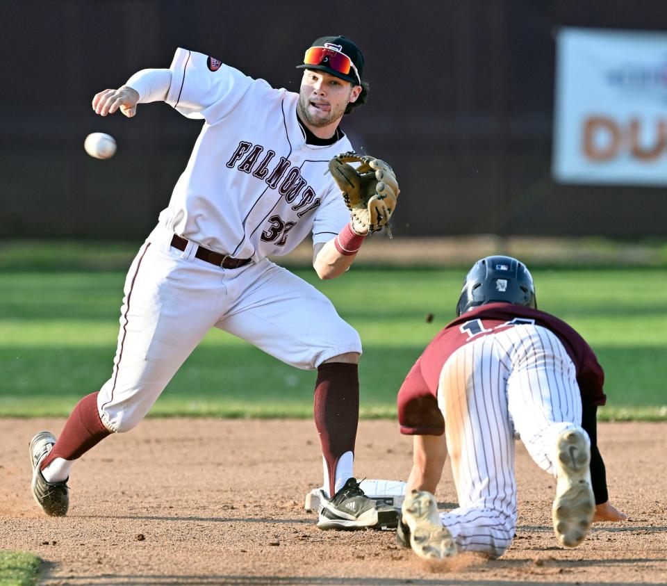 In this Wednesday game action, Falmouth shortstop Cade Clemons waits the throw as Samuel Tackett of Cotuit dives for second. He was safe on the play as the tag knocked the ball loose. Cape League baseball.