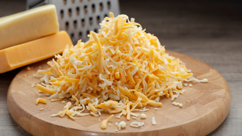 Shredded cheese on wooden board