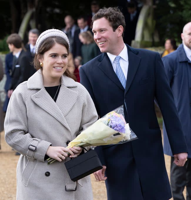 princess eugenie carries flowers beside her husband Jack Brooksbank