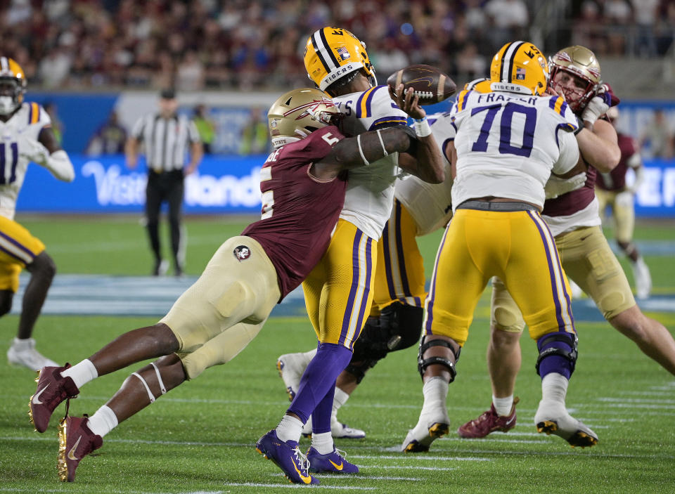 Sep 3, 2023; Orlando, Florida, USA; LSU Tigers quarterback Jayden Daniels (5) is sacked by Florida State Seminoles defensive end Jared Verse (5) during the game at Camping World Stadium. Mandatory Credit: Melina Myers-USA TODAY Sports