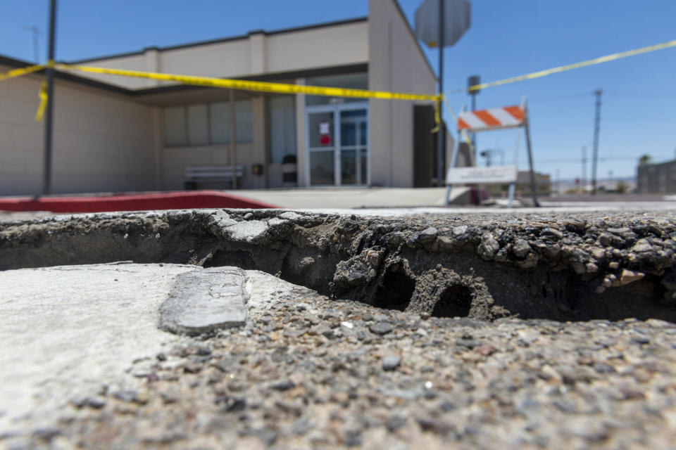 Damaged pavement from an earthquake surrounds the Searle Valley Domestic Water company in Trona, Calif., on Wednesday, July 10, 2019. The water company, the U.S. Post office building and a local restaurant were among the commercial buildings deemed unfit for occupancy after recent earthquakes. Residents of the little community of Trona gathered at a town hall Wednesday to hear officials give updates on the recovery. (James Quigg/The Daily Press via AP)