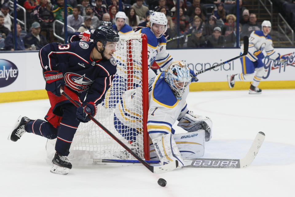 Columbus Blue Jackets' Johnny Gaudreau, left, looks for an open shot as Buffalo Sabres' Ukko-Pekka Luukkonen protects the net during the second period of an NHL hockey game Wednesday, Dec. 7, 2022, in Columbus, Ohio. (AP Photo/Jay LaPrete)
