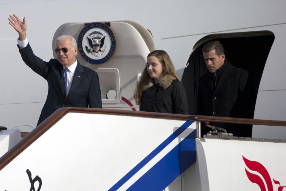 U.S. Vice President Joe Biden (L) waves as he walks out of Air Force Two with his granddaughter Finnegan Biden and son Hunter Biden at the airport in Beijing December 4, 2013. Biden should not expect to make much progress in defusing tensions over the East China Sea if he plans to repeat "erroneous and one-sided remarks" on the issue when he visits China, a top state-run paper said on Wednesday. Beijing's decision to declare an air defence identification zone in an area that includes disputed islands has triggered protests from the United States, Japan and South Korea and dominated Biden's talks in Tokyo on Tuesday.   REUTERS/Ng Han Guan/Pool  (CHINA - Tags: POLITICS)