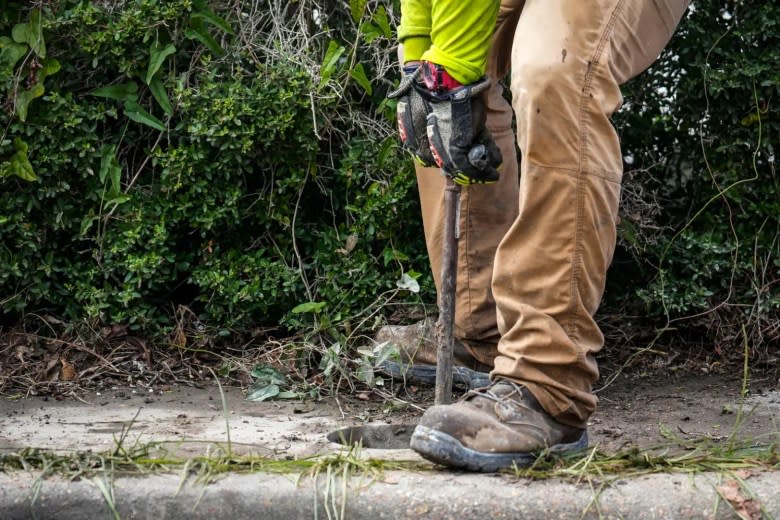 A contractor for Union Pacific drops a well pipe into a hole under the sidewalk while setting up a testing site in Fifth Ward for contaminants. Many people want Union Pacific to pay for the cleanup of the creosote plume. (Brett Coomer/Houston Chronicle via Getty Images)