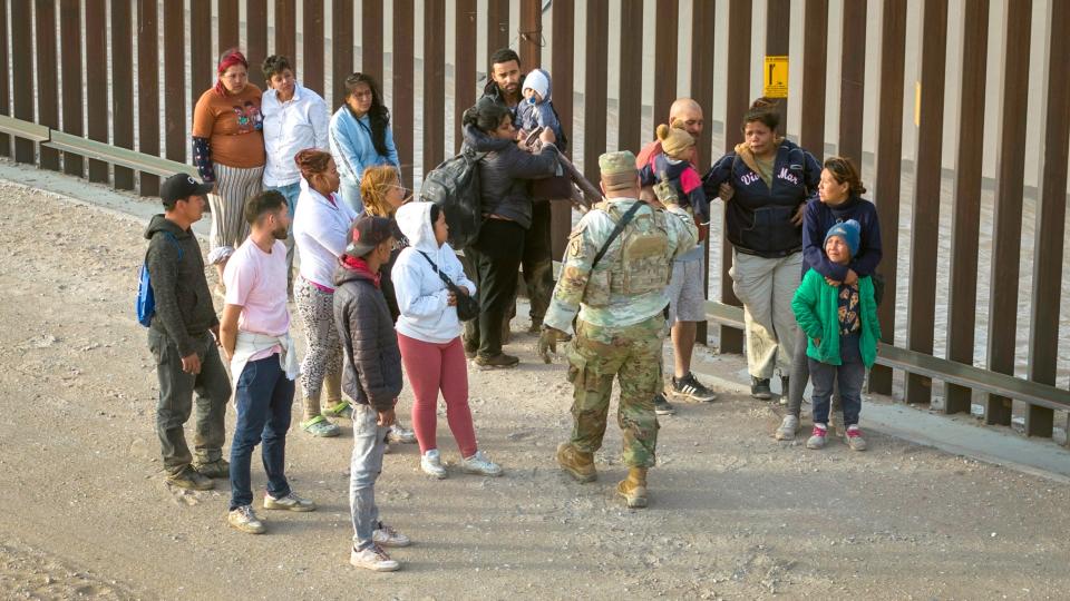 A Texas National Guard soldier counts migrants after they crossed the U.S.-Mexico border to request asylum March 13 in El Paso, Texas.