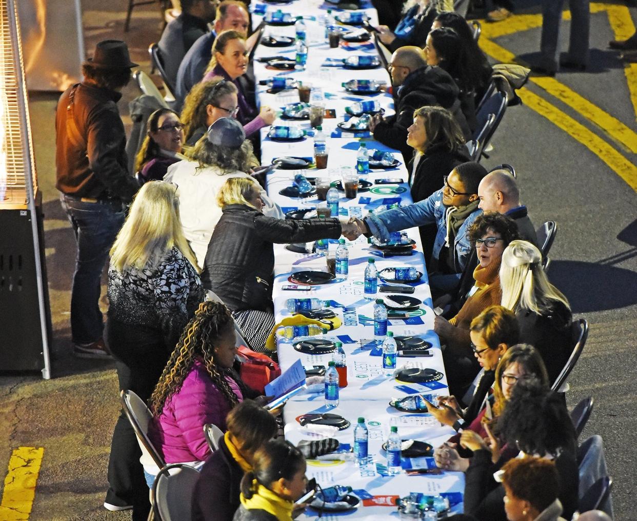 Guests greet each other at the start of the 2018 Longest Table event, an open-air dinner that stretched more than 600 feet down Independent Drive in Downtown Jacksonville. Hosted by the JAX Chamber, the annual meal is meant to connect diverse groups and build relationships across economic, racial, religious and ethnic backgrounds.