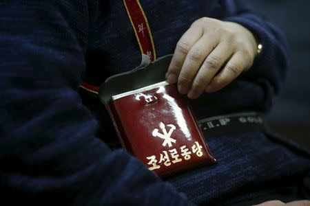 Seo Jae-pyoung, the secretary general of the association of the North Korean defectors, poses for a photograph while demonstrating the use of a Workers' Party membership card holder during an interview with Reuters in Seoul, South Korea, April 22, 2016. REUTERS/Kim Hong-Ji