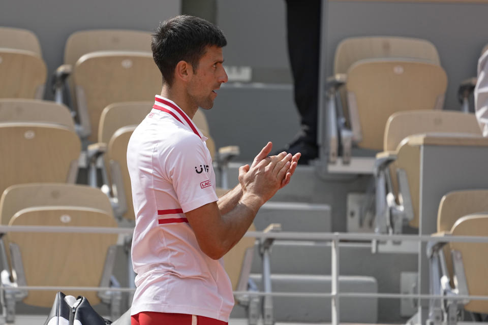 Serbia's Novak Djokovic applauds Italy's Lorenzo Musetti who leaves the court after retiring due to an injury during their fourth round match on day 9, of the French Open tennis tournament at Roland Garros in Paris, France, Monday, June 7, 2021. Djokovic beat 19-year-old Lorenzo Musetti of Italy, who retired with an injury two games from defeat in the fourth round at the French Open. (AP Photo/Michel Euler)