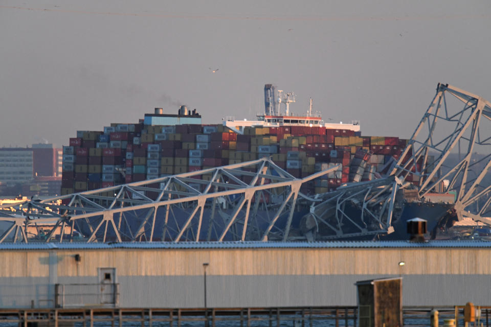 The steel frame of the Francis Scott Key Bridge sits on top of a container ship after it struck the bridge in Baltimore, Maryland, on March 26, 2024. The collapsed sent multiple vehicles and up to 20 people plunging into the harbor below. 