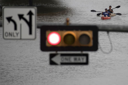 Men use kayaks to get through an intersection after heavy rain from Hurricane Harvey flooded Pearland, in the outskirts of Houston, Texas, U.S. August 27, 2017. REUTERS/Adrees Latif