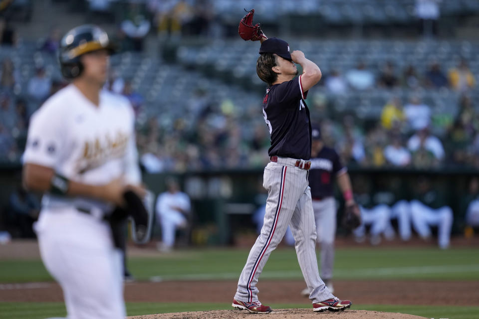 Minnesota Twins pitcher Kenta Maeda, right, reacts after giving up a walk to Oakland Athletics' Ryan Noda, foreground, during the second inning of a baseball game Friday, July 14, 2023, in Oakland, Calif. (AP Photo/Godofredo A. Vásquez)