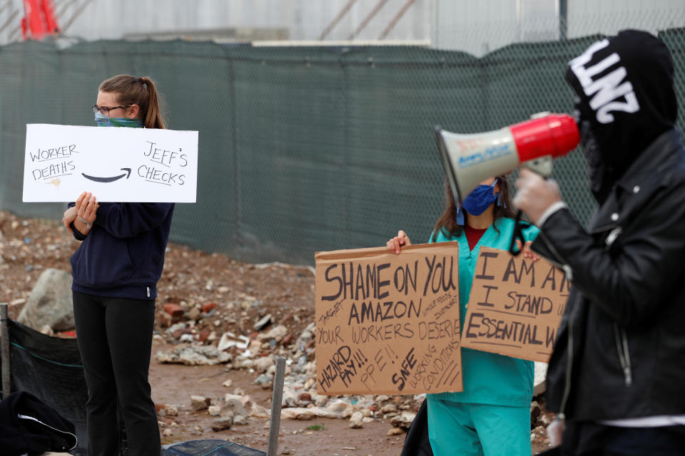 Demonstrators hold signs as they listen to former Amazon employee, Christian Smalls, speak during a protest outside of an Amazon warehouse as the outbreak of the coronavirus disease (COVID-19) continues in the Staten Island borough of New York U.S., May 1, 2020. REUTERS/Lucas Jackson