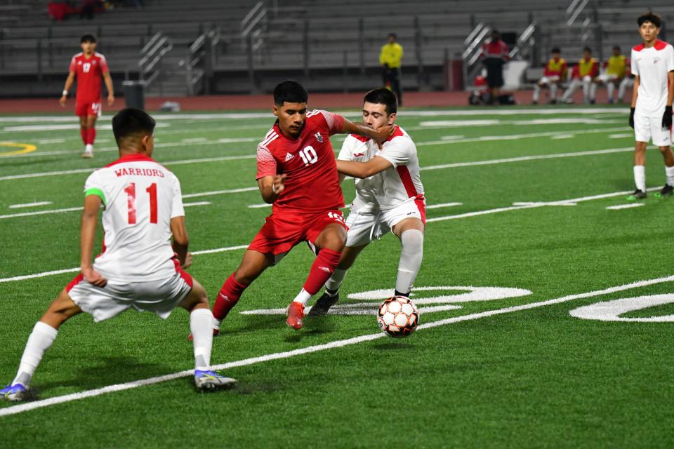 Hueneme's Andres Gutierrez splits a pair of Carpinteria defenders during the host Vikings' 4-0 Citrus Coast League win on Jan. 19.