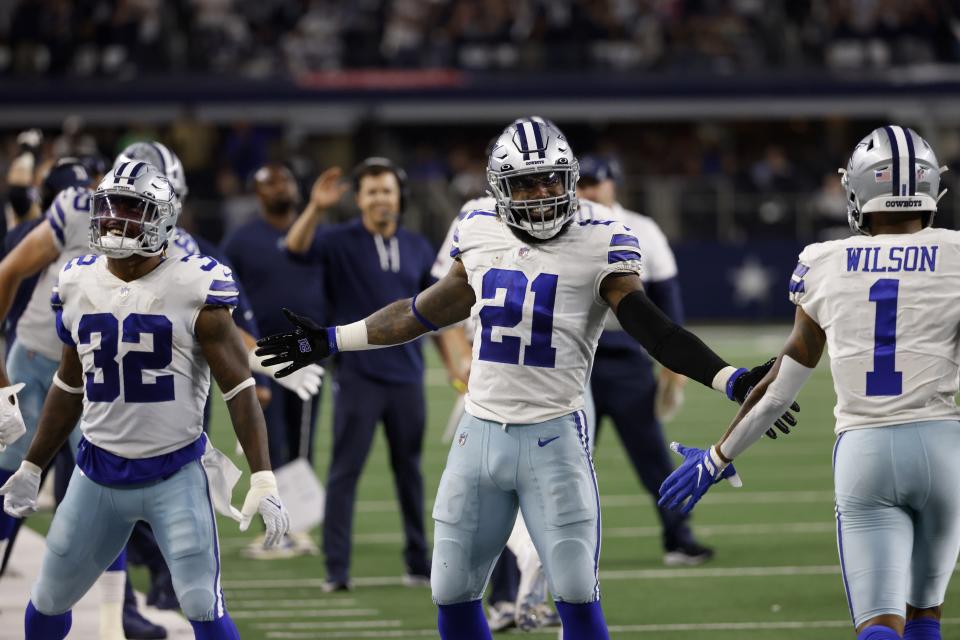 Dallas Cowboys' Corey Clement (32), Ezekiel Elliott (21) and Cedrick Wilson (1) celebrate late in the second half of an NFL football game against the Philadelphia Eagles in Arlington, Texas, Monday, Sept. 27, 2021. (AP Photo/Ron Jenkins)