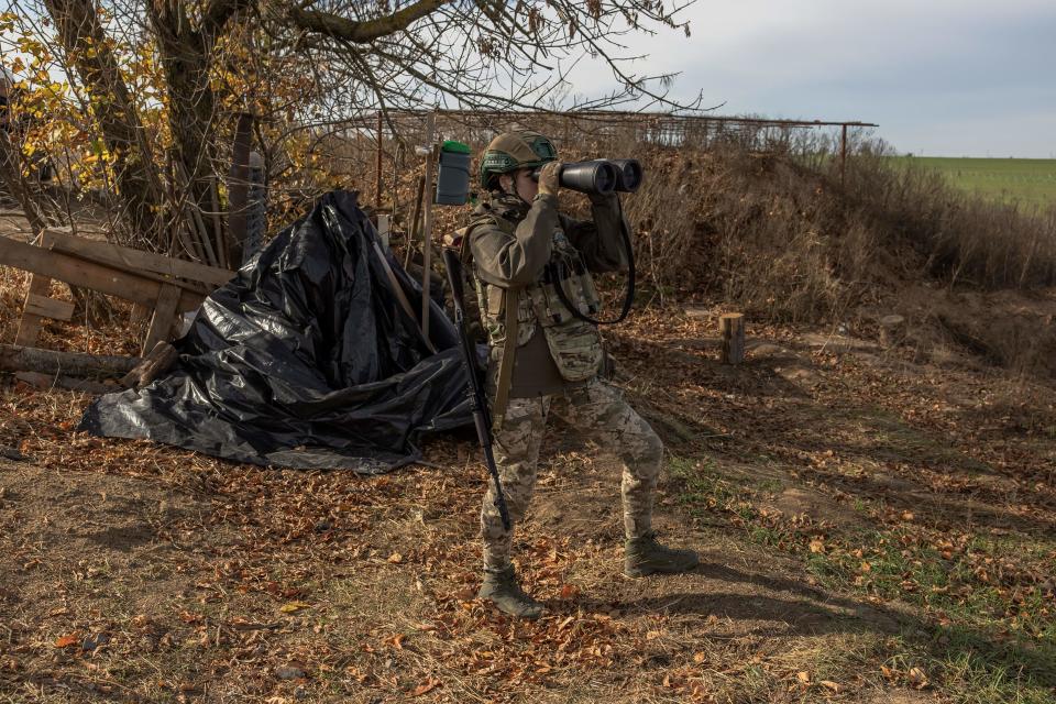 A Ukrainian military member checks the area with binoculars at a position outside the southern city of Kherson (AFP via Getty Images)