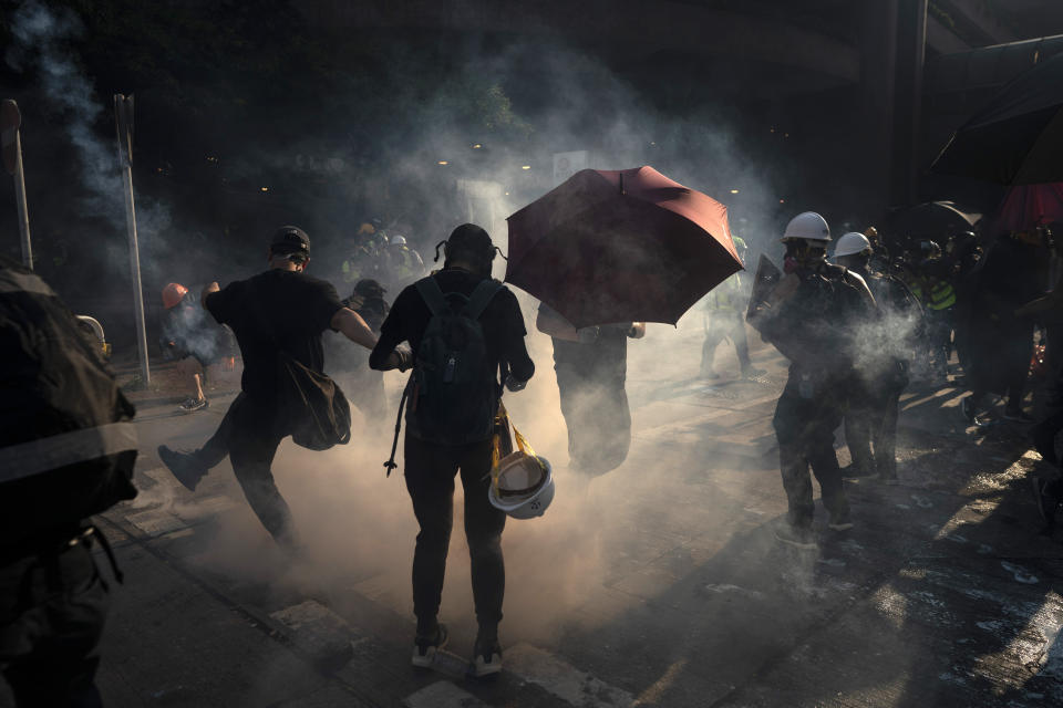 A protestor kicks back an exploded tear gas shell in Hong Kong, Tuesday, Oct. 1, 2019. Hong Kong police shot a protester at close range, leaving him bleeding from his shoulder and howling on the ground, in a fearsome escalation of anti-government demonstrations that spread across the semi-autonomous Chinese territory on Tuesday. Tens of thousands marched in a day of rage as Communist leaders in Beijing celebrated 70 years in power. (AP Photo/Felipe Dana)