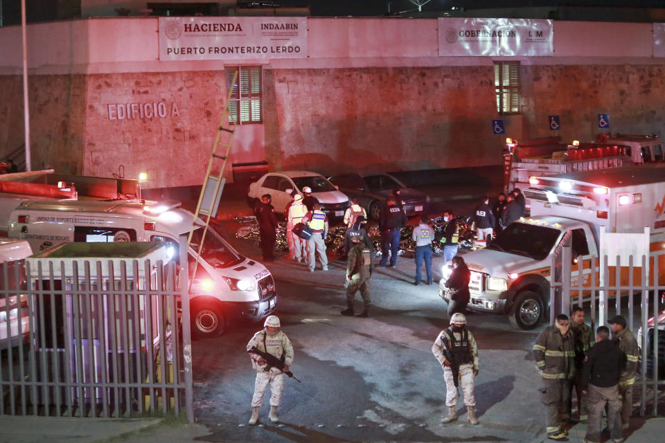 Paramedics and security forces work amid the covered bodies of migrants who died in a fire at an immigration detention center in Ciudad Juarez, Mexico, Tuesday, March 28, 2023. (AP Photo/Christian Chavez)