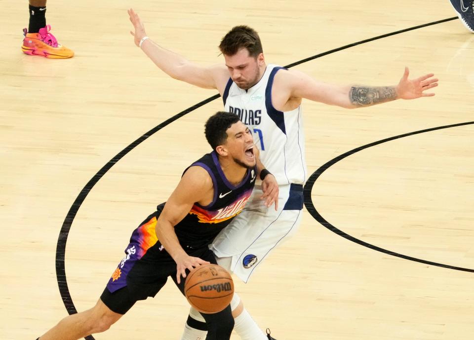 May 10, 2022; Phoenix, Arizona, USA; Phoenix Suns guard Devin Booker (1) collides with Dallas Mavericks guard Luka Doncic (77) during game five of the second round for the 2022 NBA playoffs at Footprint Center.
