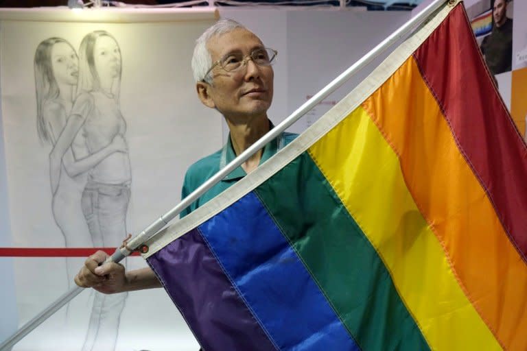 Taiwanese gay rights campaigner Chi Chia-wei, 59, poses for a photograph with a flag. Taiwan could become the first place in Asia to legalise gay marriage on Wednesday when a court makes a landmark ruling on whether to allow same-sex unions 