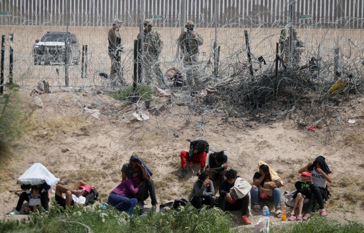 <span>The Texas national guard watch people who have just crossed the Rio Grande from Ciudad Juarez, Mexico, on 4 June 2024.</span><span>Photograph: Hérika Martínez/AFP/Getty Images</span>